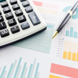 Photo of a calculator and generic financial graphs.